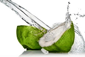 fresh cut green coconut with water splash on white